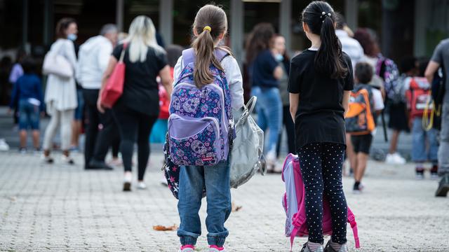 Deux élèves devant une école. (image d'illustration) [Keystone - Elia Bianchi]