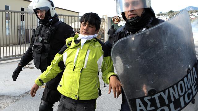 La police grecque anti-émeute arrête un migrant près du camp de réfugiés de Moria, sur l'île de Lesbos, le 2 mars 2020. [reuters - Elias Marcou]