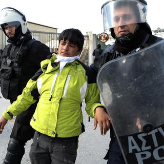 La police grecque anti-émeute arrête un migrant près du camp de réfugiés de Moria, sur l'île de Lesbos, le 2 mars 2020. [reuters - Elias Marcou]