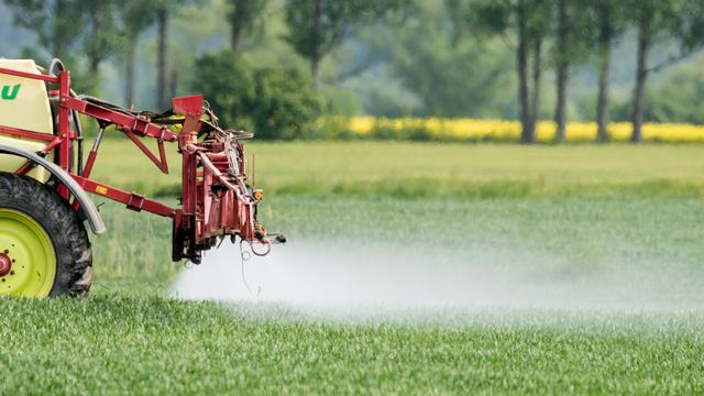 Un tracteur épand des pesticides. [DPA/Keystone - Patrick Pleul]