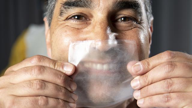 Thierry Pelet, chef du projet Hello Mask à l'EPFL avec un échantillon de la matière transparente dont seront faits les masques. [Keystone - Laurent Gillieron]