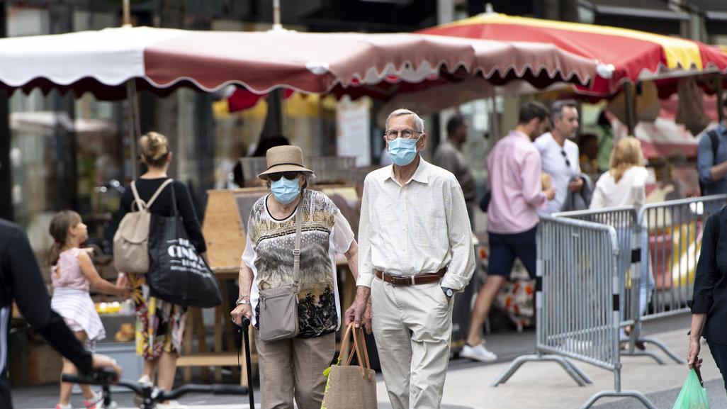 En Suisse, le port du masque n'est obligatoire nulle part en extérieur (ici au marché à Lausanne), mais cela pourrait changer. [Keystone - Laurent Gilliéron]