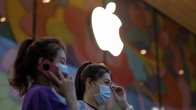 Deux femmes devant un Apple Store à Pékin. [Keystone/AP Photo - NgHan Guan]