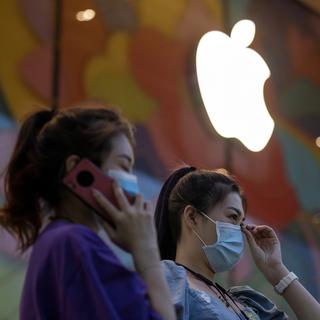 Deux femmes devant un Apple Store à Pékin. [Keystone/AP Photo - NgHan Guan]