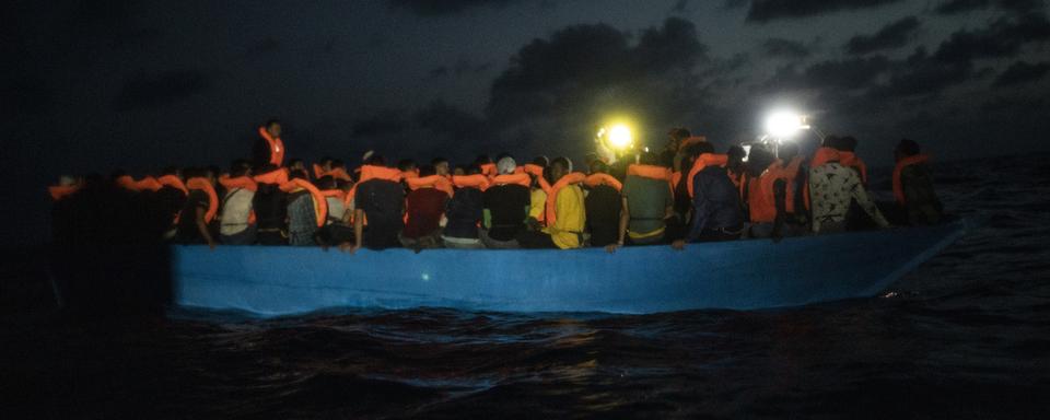 Des migrants sur un bateau au large de la Libye (image d'illustration). [Keystone/AP Photo - Santi Palacios]