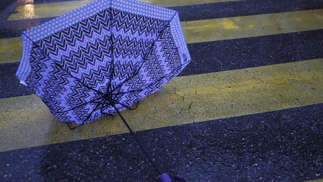 Un parapluie cassé sur un passage pietons à Genève (image d'illustration). [Keystone - Salvatore Di Nolfi]