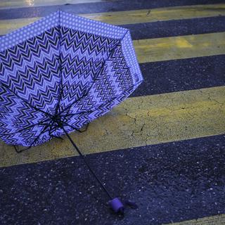 Un parapluie cassé sur un passage pietons à Genève (image d'illustration). [Keystone - Salvatore Di Nolfi]