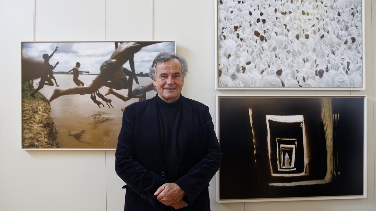 Le photographe Bruno Barbey devant ses clichés à l'Académie française des Beaux-Arts, à Paris, le 13 avril 2016. [AFP - FRANCOIS GUILLOT]