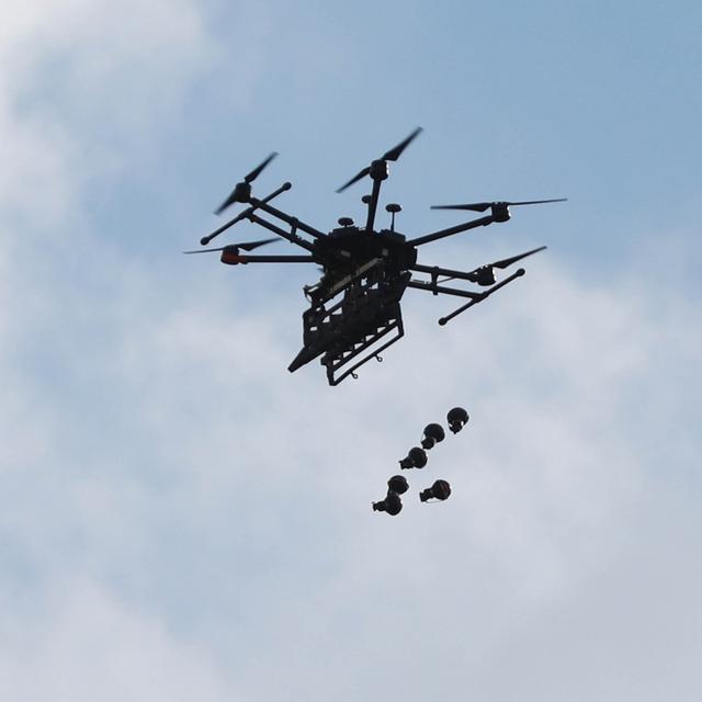 Un drone larguant des gaz lacrymogènes pour disperser les manifestants lors d'une manifestation. [AFP - Issam Rimawi / ANADOLU AGENCY]