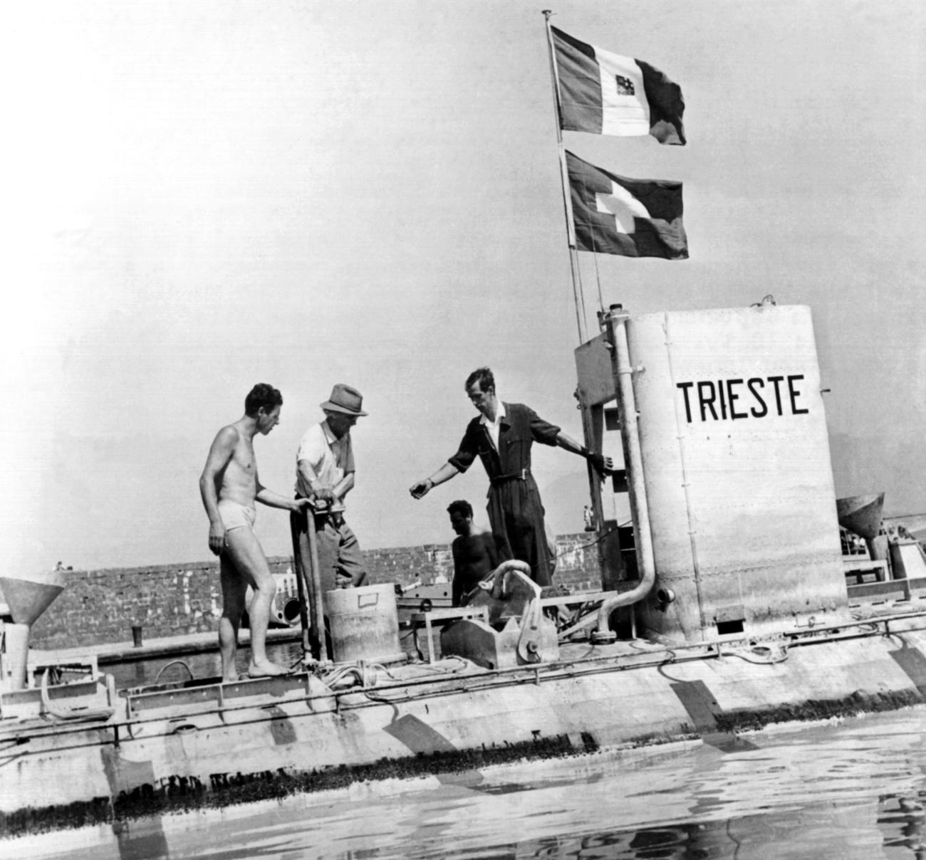 Auguste Piccard, avec le chapeau, et son fils Jacques, à droite, testent leur bathyscaphe "Trieste" dans la Baie de Naples, le 13 août 1953. [Keystone - Photopress-Archiv/str]