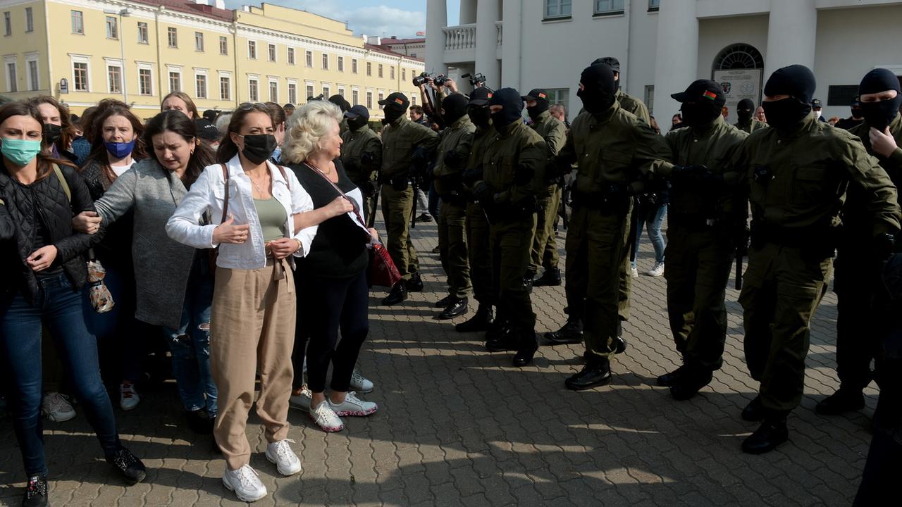 Des femmes biélorusses font face aux forces de l'ordre lors de manifestations à Minsk. [Keystone/EPA/STR]