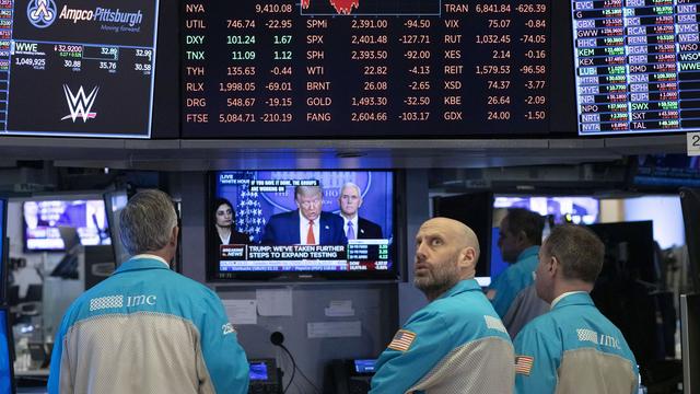 Sur cette photo prise le 18 mars 2020, des traders de Wall Street, la bourse new yorkaise, regardent une conférence télévisée du président Donald Trump. [Keystone - MARK LENNIHAN]