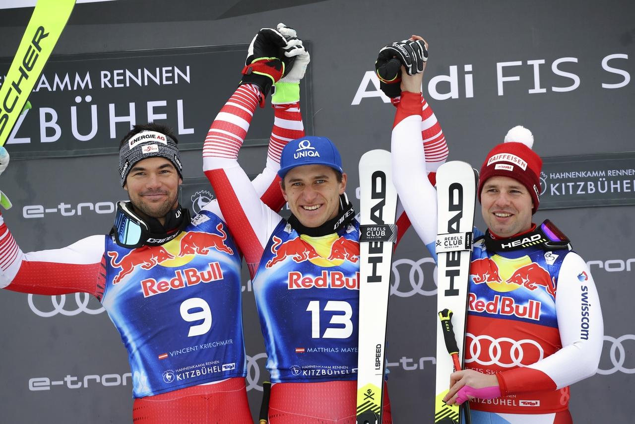 Feuz accompagné de ses deux adversaires autrichiens [Keystone - Marco Trovati]