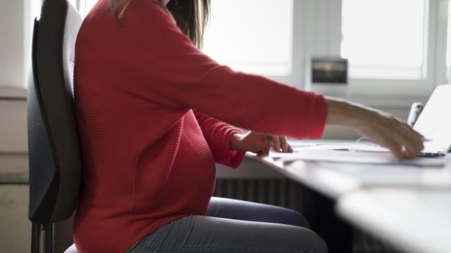 Une femme enceinte au travail. [Keystone - Gaetan Bally]