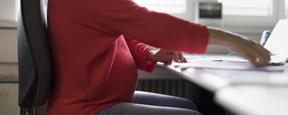 Une femme enceinte au travail. [Keystone - Gaetan Bally]