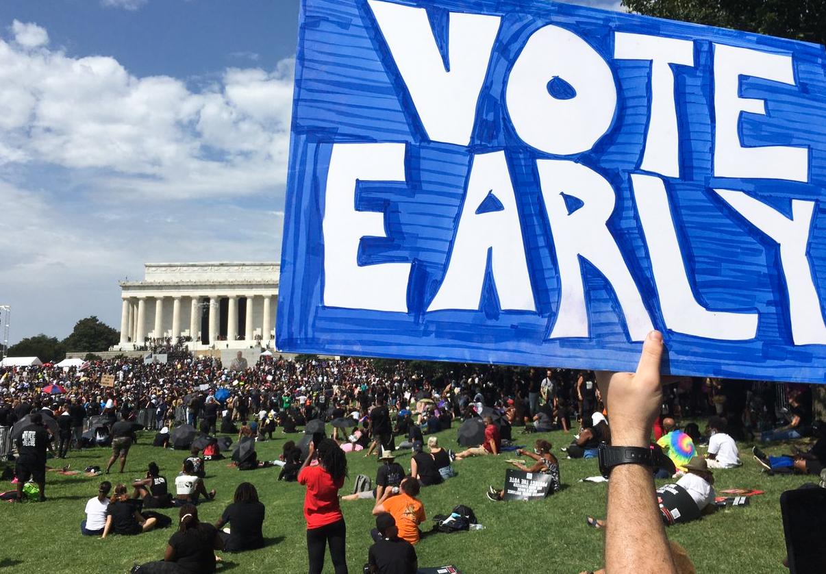 Une pancarte disant "Votez tôt" lors du rassemblement contre le racisme et les violences policières, le 28 août 2020 à Washington. [AFP - Artur Gabdrahmanov]