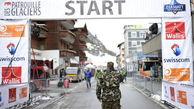 Un militaire dans l'aire de départ de la Patrouille des Glaciers à Zermatt. [Keystone - Maxime Schmid]