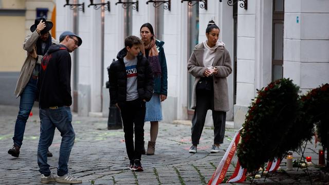 Des passants devant des couronnes fleuries en hommages aux victimes de la fusillade qui a fait 4 morts le 2 novembre 2020. [EPA/Keystone - Florina Wieser]