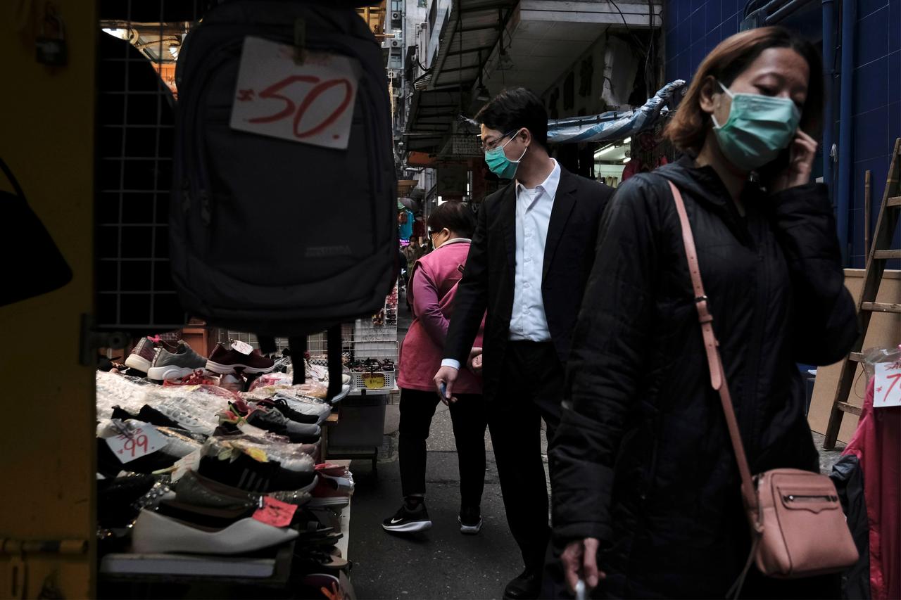 Des gens portent des masques de protection dans le district financier de Hong Kong, le lundi 2 mars. [Reuters - Tyrone Siu]