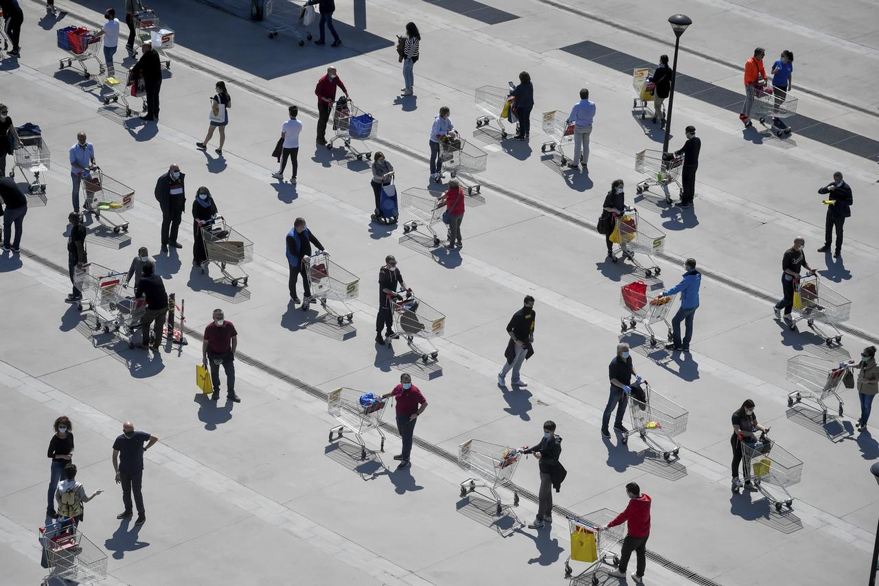 Les gens attendent dans une longue file pour enter dans un supermarché de San Donato, dans la banlieue de Milan. Italie, le 11 avril 2020. [Keystone/AP LaPresse - Claudio Furlan]