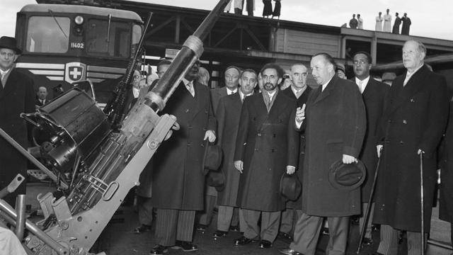 L'entrepreneur zurichois Emil Georg Bührle (au centre) a fait sa fortune en fabriquant des armes, notamment des canons, à Oerlikon. Ici, en 1954, avec Tafari Makonnen (à gauche), régent d'Ethiopie et dernier empereur d'Abyssinie. [KEYSTONE/Ilse Guenther]