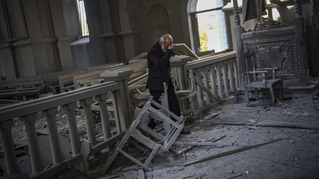 Un homme prie dans la cathédrale endommagée Ghazanchetsots de Shusha, à 15 kilomètres de la ligne de front. [AFP - Aris Messinis]