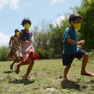 Des enfants portant des masques jouent, le 20 avril 2020 dans le district d'Assam en Inde. [EPA/Keystone]