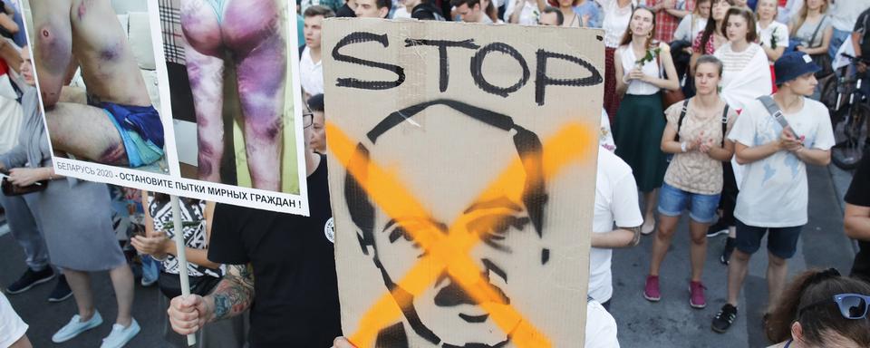 Des opposants à Alexandre Loukachenko défilent dans les rues de Minsk. [Keystone/AP Photo - Dmitri Lovetsky]