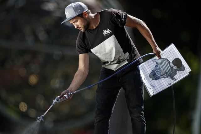 L'artiste franco-suisse Saype est connu pour ses graffitis gigantesques et éphémères réalisés sur gazon. [keystone - Valentin Flauraud]