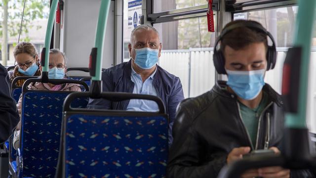 Des personnes masquées dans un bus. [KEYSTONE - Salvatore Di Nolfi]