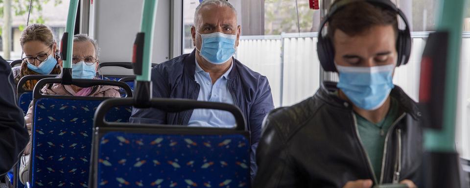 Des personnes masquées dans un bus. [KEYSTONE - Salvatore Di Nolfi]