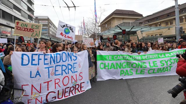 Les jeunes manifestants ont préparé leur banderole pour la marche pour le climat. [RTS - Guillaume Martinez]