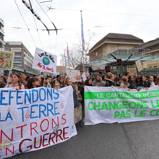 Les jeunes manifestants ont préparé leur banderole pour la marche pour le climat. [RTS - Guillaume Martinez]