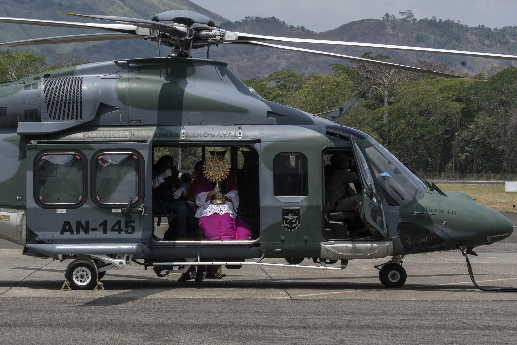 Jose Domingo Ulloa, l'archevêque du Panama, à bord d'un hélicoptère pour aller donner sa bénédiction aux fidèles. Panama City, le 5 avril 2020. [AFP - Luis Acosta]