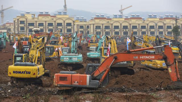 Le ballet des pelles mécaniques pour construire un nouvel hôpital à Wuhan. [Keystone - Chinatopix via AP]