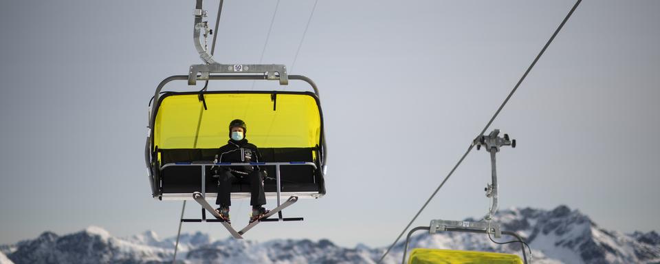 Un skieur portant un masque, le 25 octobre à Davos. [Keystone - Gian Ehrenzeller]