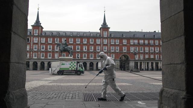 Le personnel sanitaire a désinfecté les rues et les transports publics à Madrid depuis le début du confinement, ici sur la Plaza Mayor le 18 mars 2020. [Keystone - Manu Fernandez]