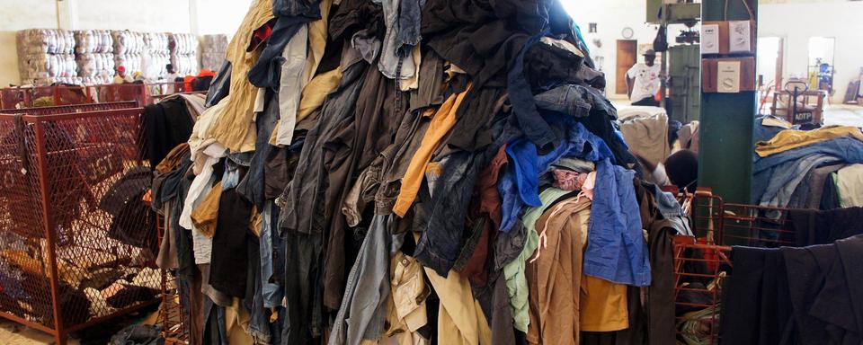 Une photo prise le 25 juin 2019 montre une pile de vêtements d'occasion au centre de recyclage textile de l'entreprise sociale française "Le Relais" à Diamniadio, au Sénégal. A Diamniadio, où l'entreprise sociale française Le Relais est implantée depuis 2006, 51 collaborateurs sont chargés du tri de 200 à 250 tonnes de vêtements d'occasion par an. [AFP - Mariama DARAME]