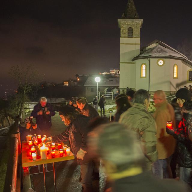 Les habitants de Daillon (Valais) participent à une marche en hommage aux victimes mortes lors d'une fusillade en janvier 2013. [Keystone - Jean-Christophe Bott]