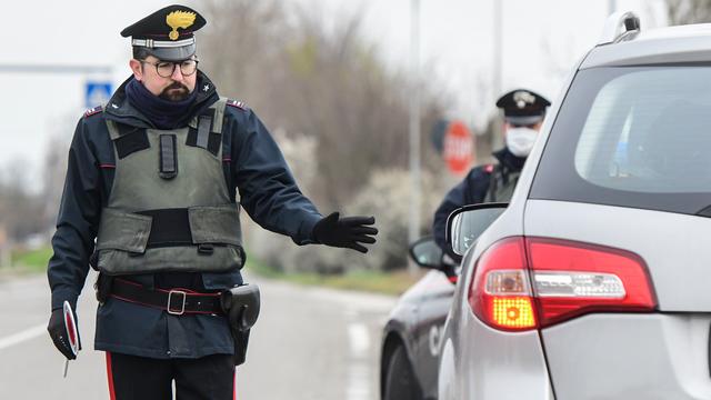 Des policiers italiens effectuent des contrôles routiers en lien avec les mesures de restriction liées au coronavirus, à Valsamoggia près de Bologne, le 9 mars 2020. [AFP - Piero Cruciatti]