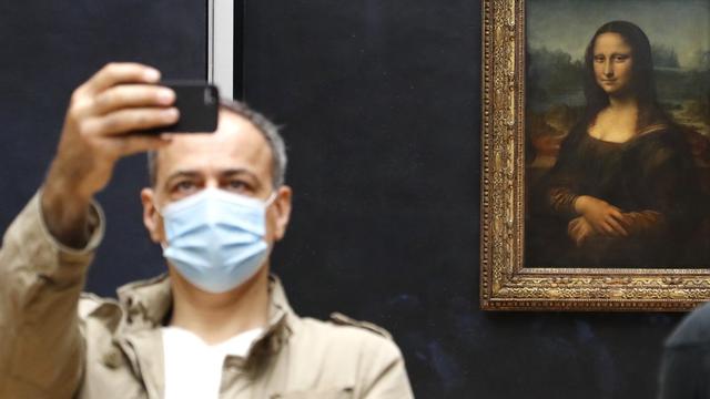 L'inamovible Mona Lisa s'amuse désormais des visiteurs masqués lui tirant le portrait au Louvre. Paris, le 6 juillet 2020. [AFP - François Guillot]