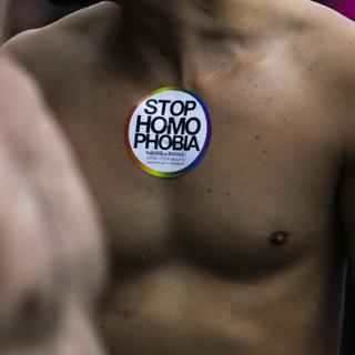 Un homme pose avec un sticker "Stop homophobia" lors de la gay pride de Berlin, en 2017. [AP Photo/Keystone - Markus Schreiber]