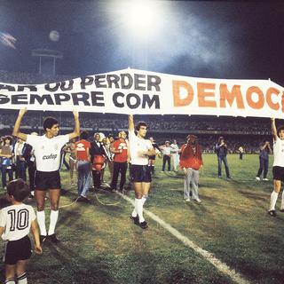 La célèbre banderole des Corinthians: "Gagner ou perdre, mais toujours avec démocratie". [Capture d'écran du documentaire "Sur la route avec Sócrates" (2014).]