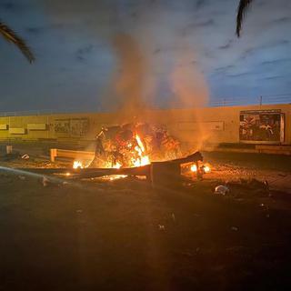 Un véhicule en feu à l'aéroport de Bagdad, après le raid américain, ce 3 janvier 2020. [Iraqi Prime Minister Press Office via AP]