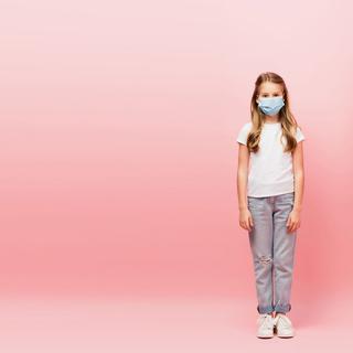 Une enfant qui porte un masque chirurgical est isolée. [Depositphotos - VitalikRadko]
