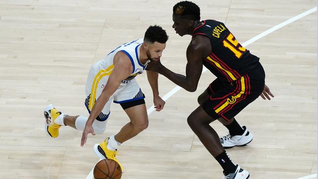 Clint Capela (droite) et les Hawks ont battu les Warriors de Stephen Curry (gauche). [John Bazemore]