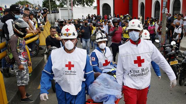 Des membres de la Croix-Rouge colombienne emporte le corps d'un homme à Cali, en Colombie, le 28 mai 2021. [Keystone/epa - Ernesto Guzman Jr]