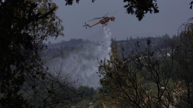 Un hélicoptère en opération au nord d'Athènes, le 11 août 2021. [Keystone - Petros Karadjias]