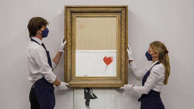 "La fille au Ballon" partiellement autodétruite de Banksy a été vendue 23 millions de francs. [AP/Keystone - Sotheby's Auction House]