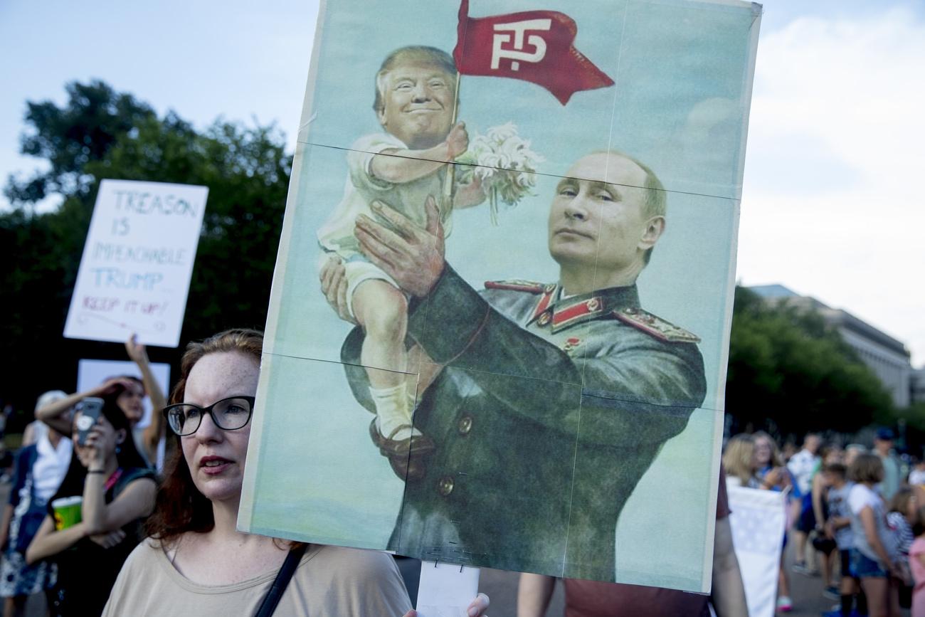 Une manifestante américaine avec une pancarte mettant en cause la relation entre Donald Trump et Vladimir Poutine. [AP/Keystone - Andrew Harnik]